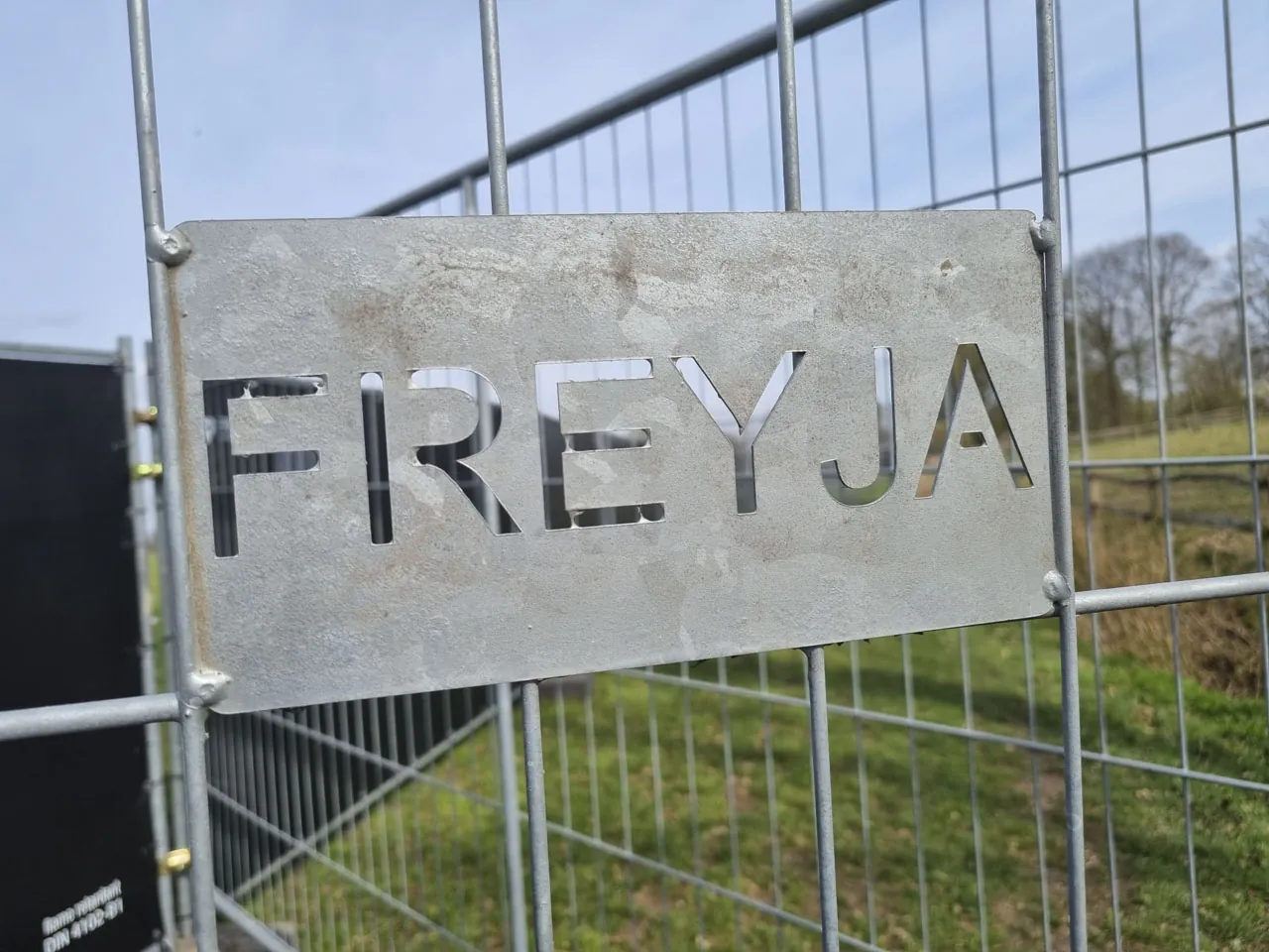 Stalen Freyja-bord op een hek